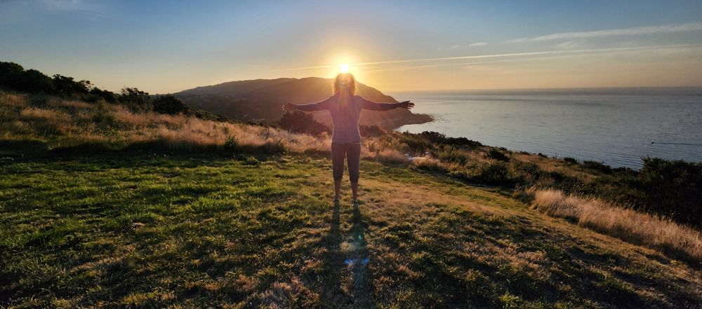 My wife standing in front of the setting sun.