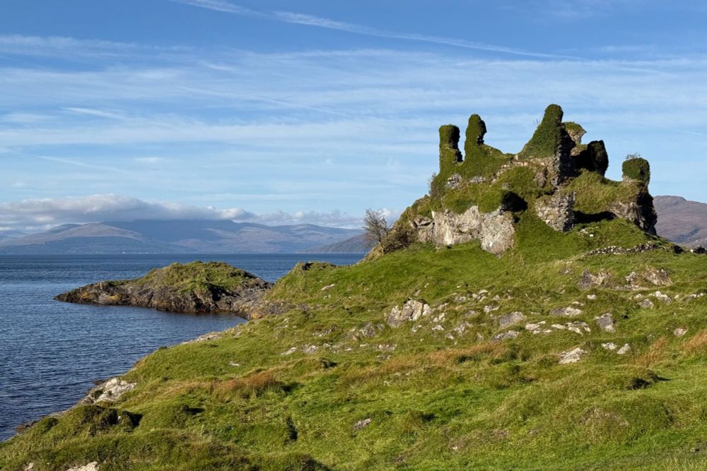 Ruined castle clad in vegetation, on coastline