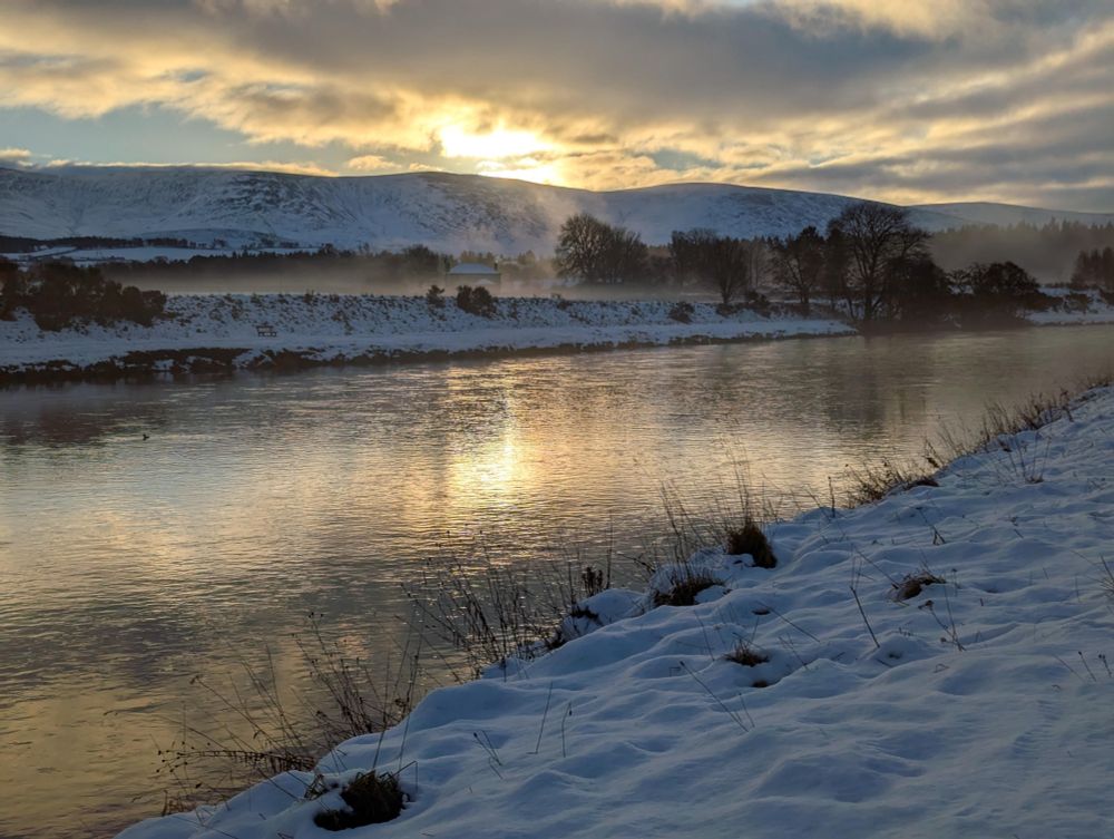 Morning sun on river through snowy landscape