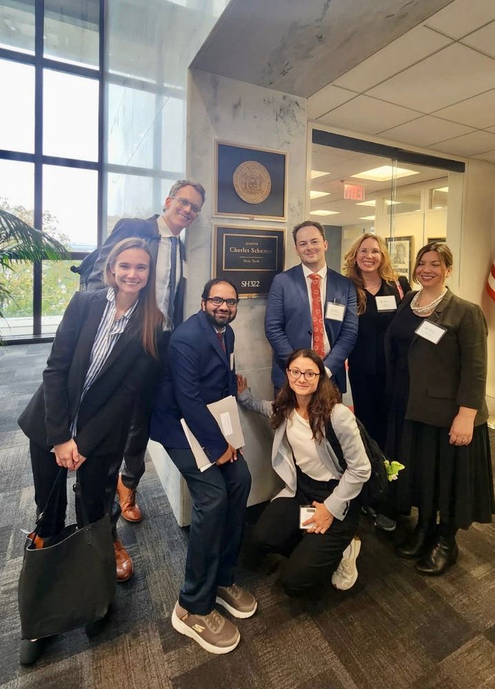 Group of people in business attire in front of the office of Senator Schumer