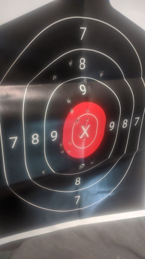 Black small target with 7 8 and 9 rings circling a red "bullseye" in the image, there are 19 holes scattered within the number 8 circle. 20th round zinged on a flinch. This grouping was had with one hand from 50 feet away, or 17 yards. This 17 yard accuracy is fairly impressive with one hand. Derain Collier 