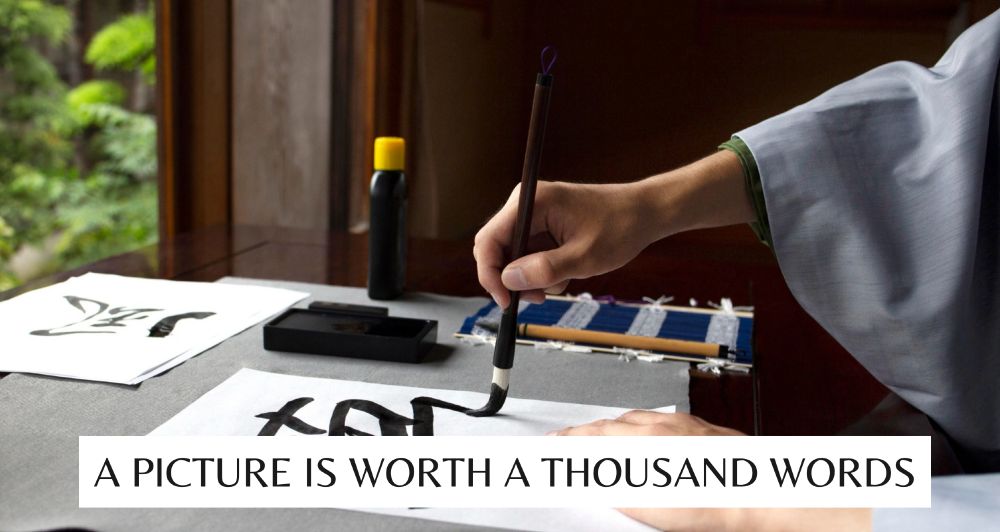 Screenshot of a presentation slide with a person doing unspecified Asian calligraphy with the subtitle "A picture is worth a thousand words"