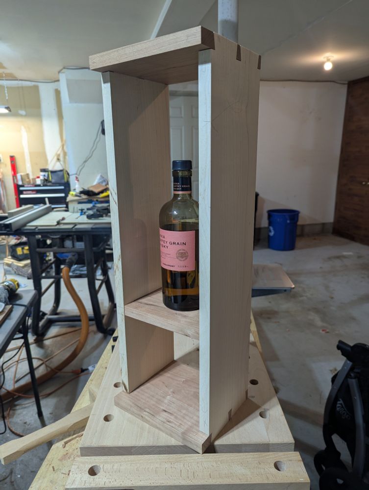 In progress whiskey cabinet displaying a bottle of whiskey.