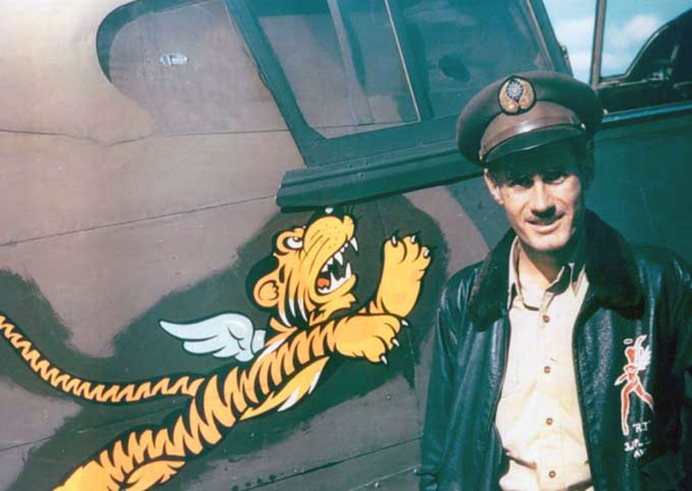 Photo: Flight leader and fighter ace Robert "R.T." Smith stands next to his P-40 fighter at Kunming, China. The "Flying Tiger" insignia was created by the Walt Disney Company. Smith is wearing a type of leather and wool fighter jacket.