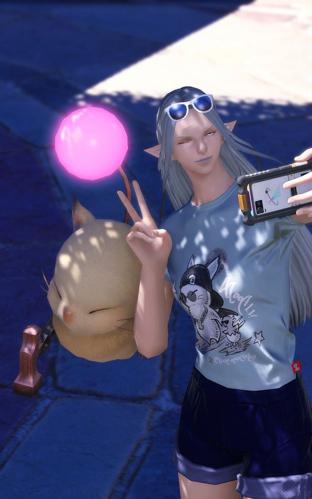 A vertical picture of Ysayle taking a selfie with a moogle. She's wearing a form-fitting shirt with moogle and a chocobo on it.