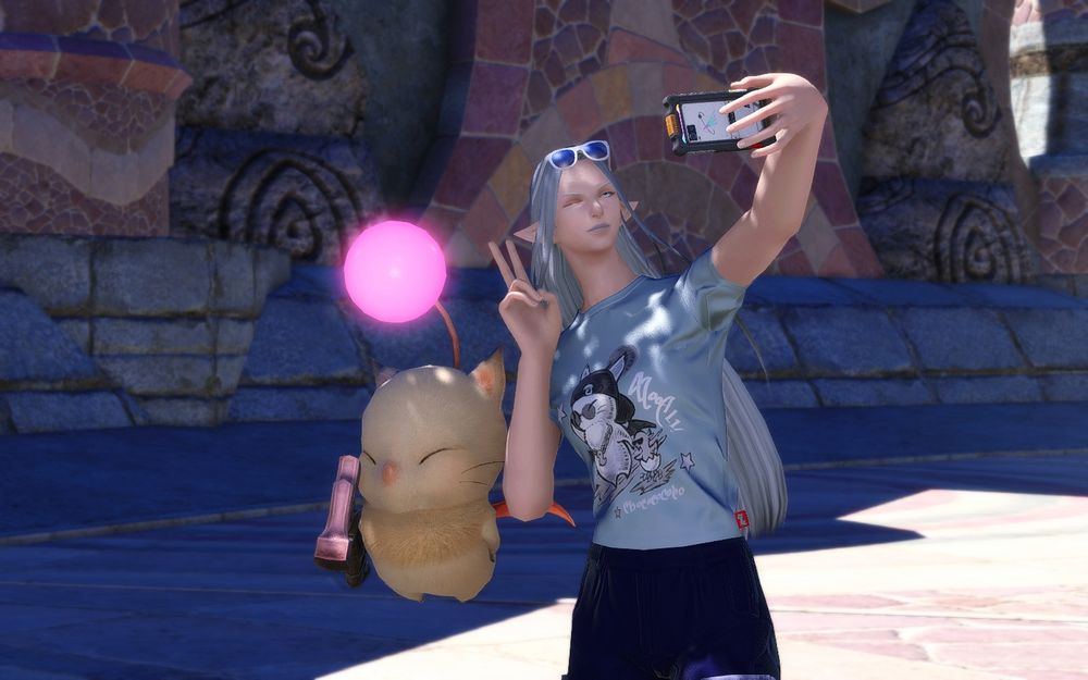 A picture of Ysayle taking a selfie with a moogle. She's wearing a form-fitting shirt with moogle and a chocobo on it.