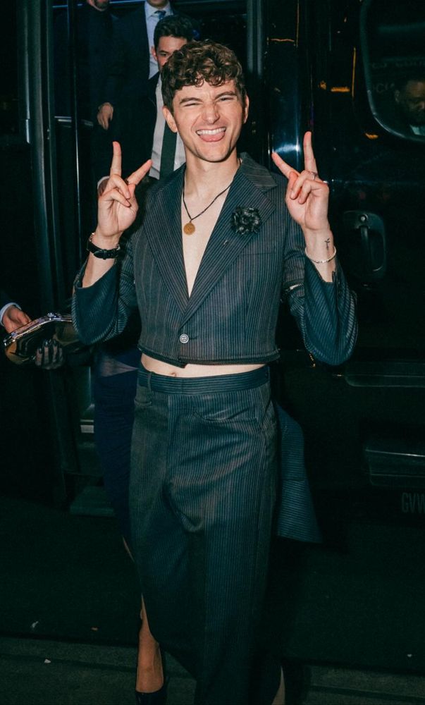 blake holding up two peace signs walking out of a bus to the hazbin premiere
