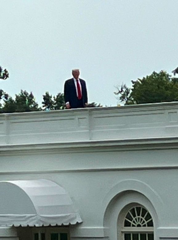 Picture of President Trump standing on the roof of the White House.