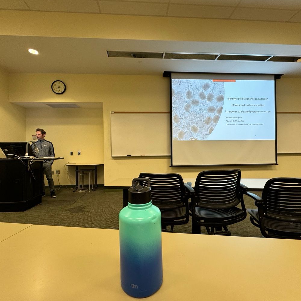 Student presenting in front of a PowerPoint