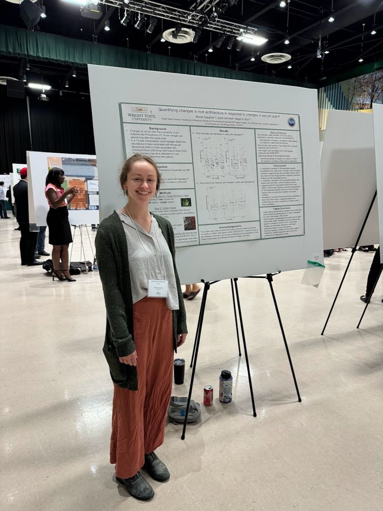 Student standing in front of a research poster.