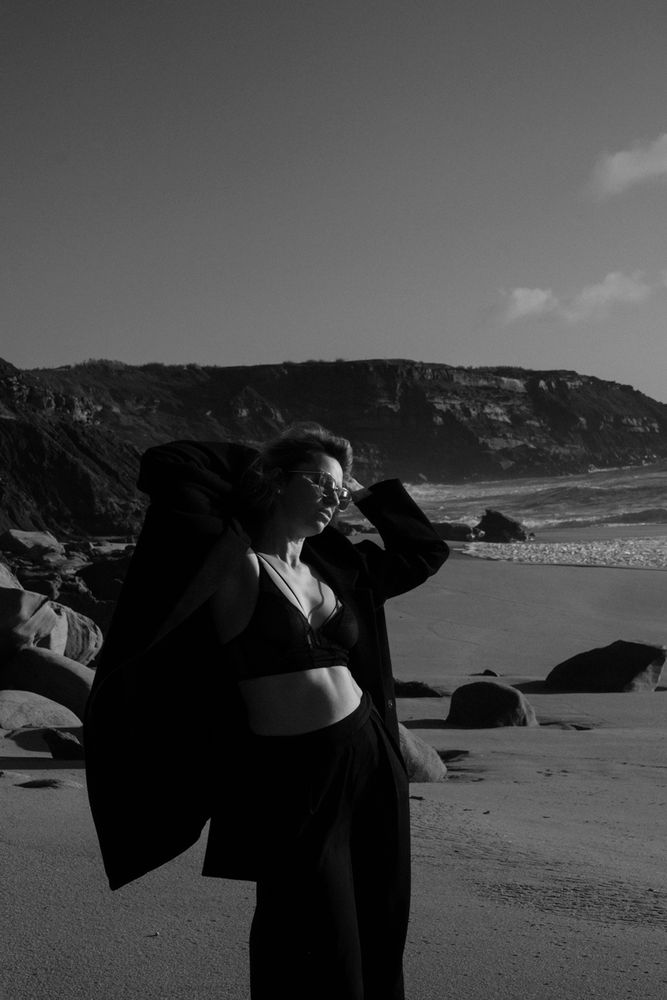 Woman on the beach in Portugal in a Black trouser and a coat
