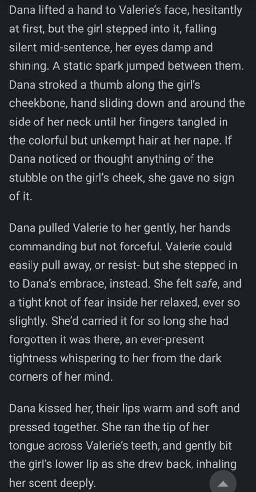 a section of quiet dot ink's writing:

Dana lifted a hand to Valerie’s face, hesitantly at first, but the girl stepped into it, falling silent mid-sentence, her eyes damp and shining. A static spark jumped between them. Dana stroked a thumb along the girl’s cheekbone, hand sliding down and around the side of her neck until her fingers tangled in the colorful but unkempt hair at her nape. If Dana noticed or thought anything of the stubble on the girl’s cheek, she gave no sign of it.

Dana pulled Valerie to her gently, her hands commanding but not forceful. Valerie could easily pull away, or resist- but she stepped in to Dana’s embrace, instead. She felt safe, and a tight knot of fear inside her relaxed, ever so slightly. She’d carried it for so long she had forgotten it was there, an ever-present tightness whispering to her from the dark corners of her mind.

Dana kissed her, their lips warm and soft and pressed together. She ran the tip of her tongue across Valerie’s teeth, and gently bit the girl’s lower lip as she drew back, inhaling her scent deeply.