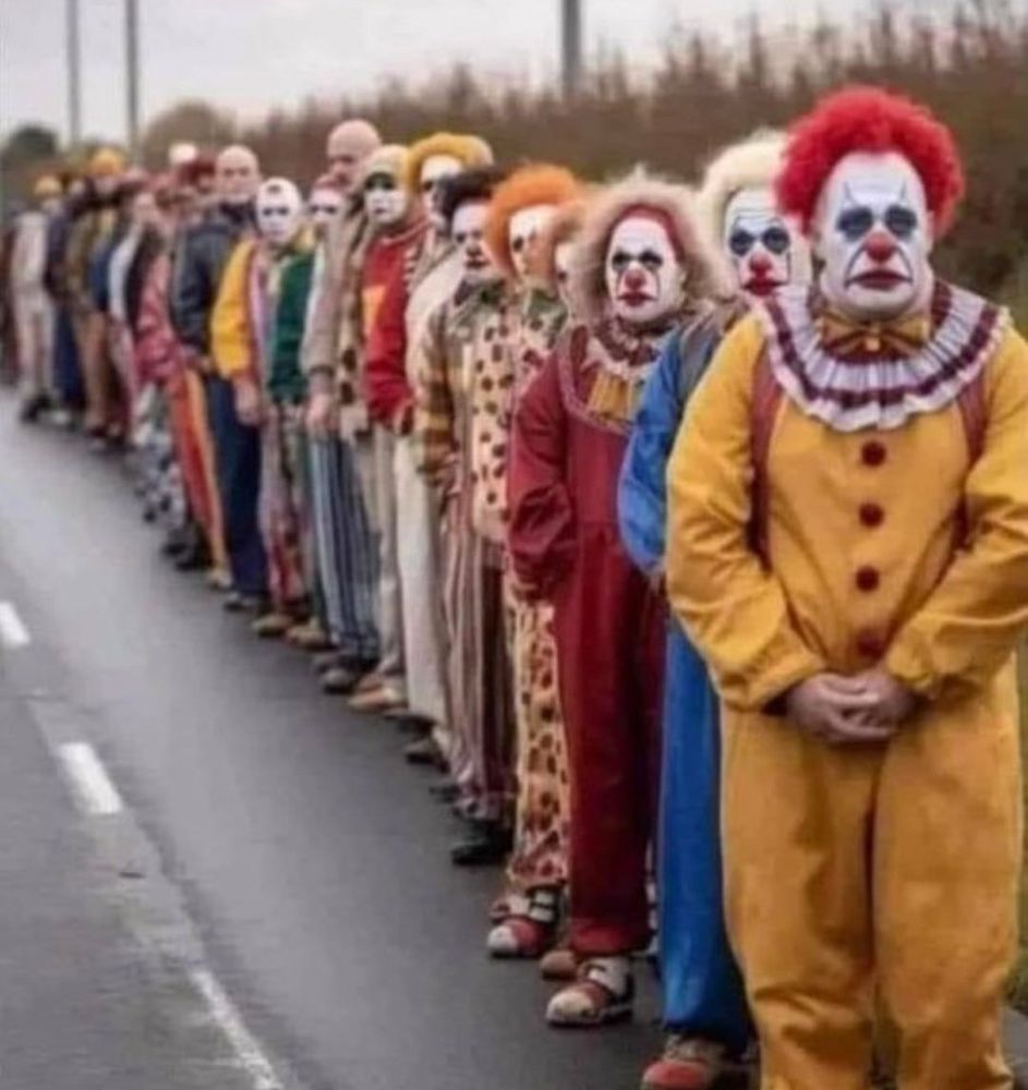 Picture of about 50 clowns standing in a line.