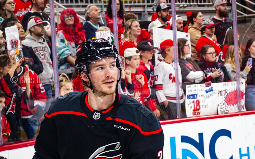 Andrei Svechnikov in the black canes jersey looking off in the direction of the jumbotron while skating around during warm ups