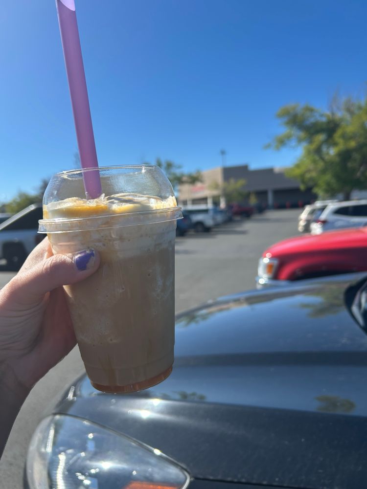 my white hand (with chopped purple polish) holding a salted caramel latte frappe from mugshot espresso (but outside costco in reno because as previous employees, it’s a treat to stop in ones out of state)