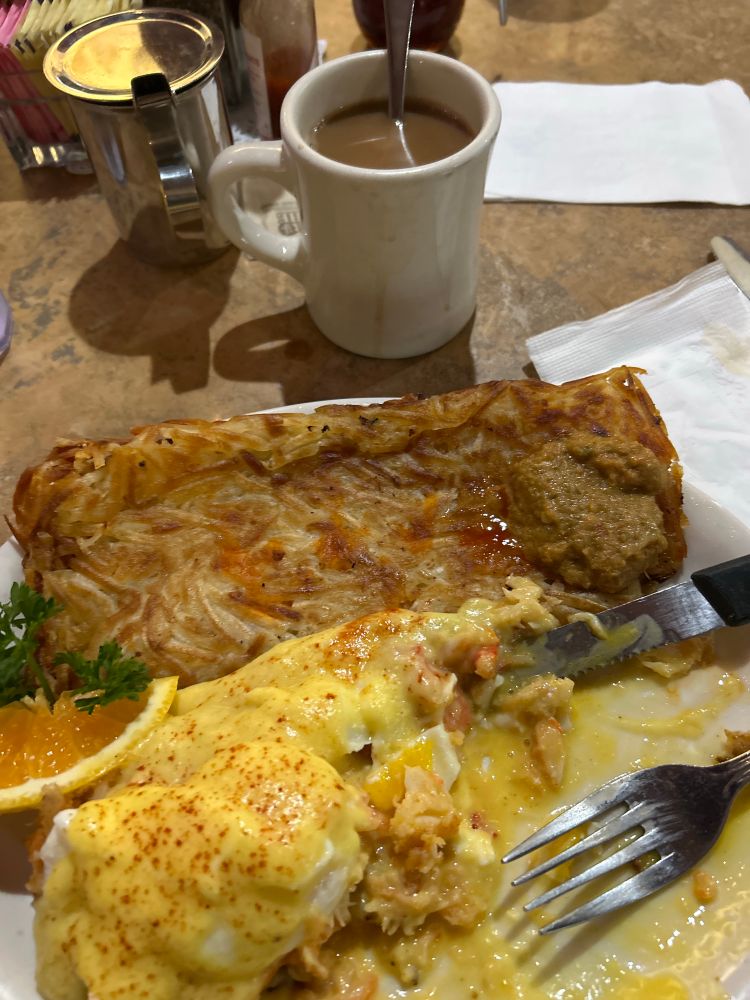 half eaten crab benedict, crispy hash browns, coffee 