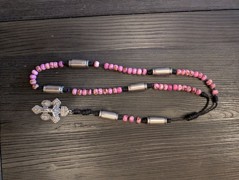 a rosary made with bullet shells and rose pink stones, which combine to a blend of extreme masculinity and extreme femininity in a very silly way