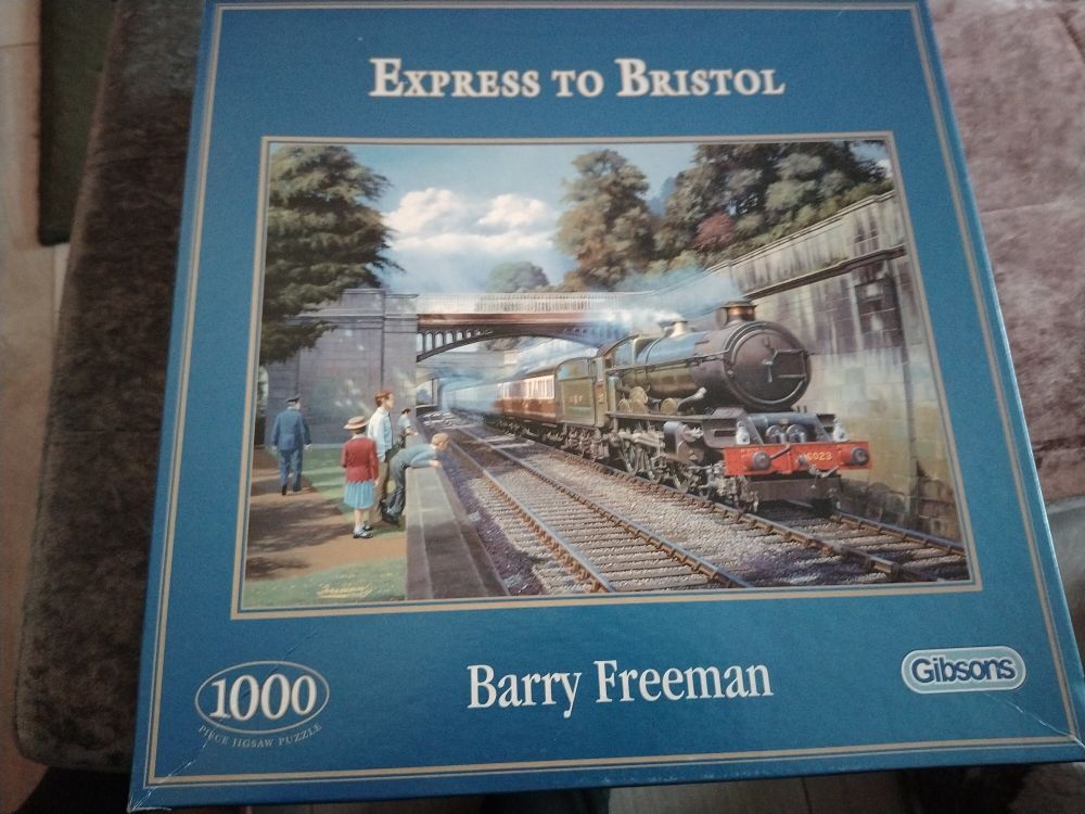 Large blue jigsaw box with an image of a steam train going through a park in Bath.