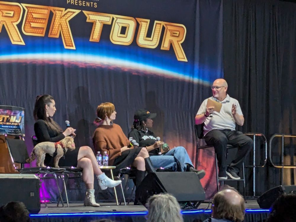 From right to left, moderator Ian Spelling, Celia Rose Gooding, Jess Bush, Christina Chong, and her dog Runa standing on a chair beside Christina.