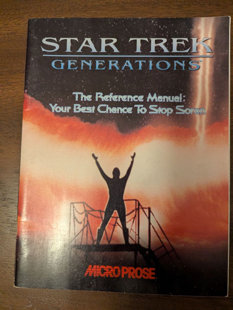 The original game reference manual for the PC game Star Trek Generations laying on a table.