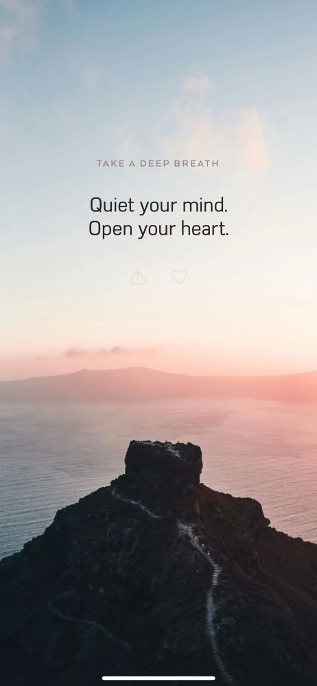 A serene mountain path leads to a rocky peak overlooking calm ocean waters at sunset. The sky is soft blue fading into warm hues of pink and peach. At the top of the image, minimalist text reads: “Take a deep breath. Quiet your mind. Open your heart.”