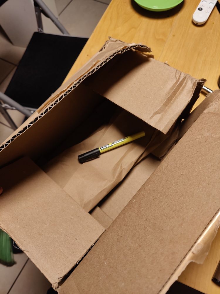 A single, tiny permanent marker in a box that is much too large for it