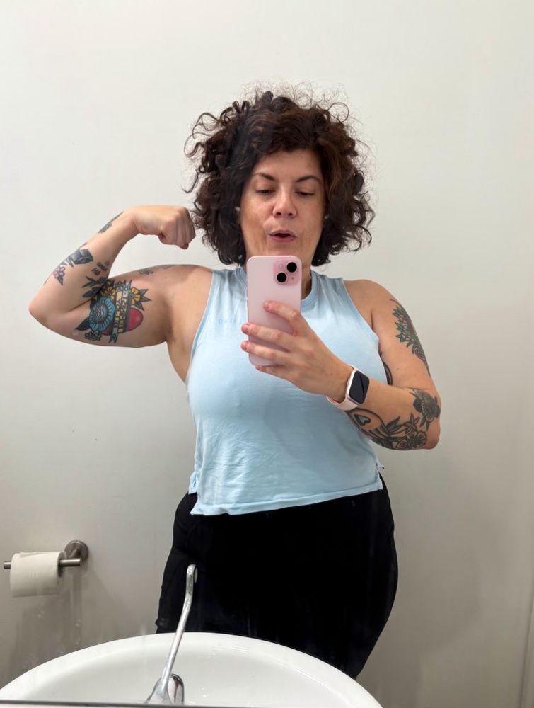 Mia flexing bicep and upper body before a lifting session