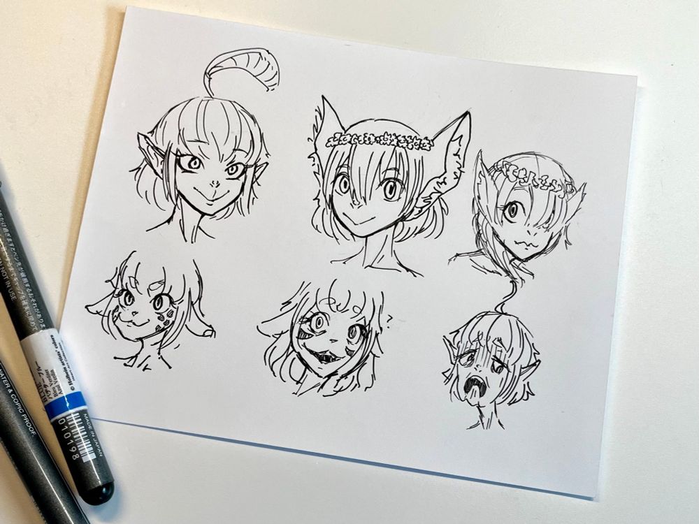 On a small piece of paper are 6 doodles of face with different attributes and expressions, the top row being neutral to happy faces below from happy to disgusted-ish. The faces shown are of 3 different characters with different design changes.