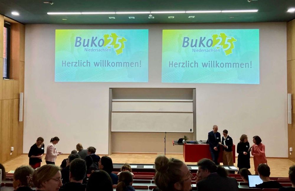 Start des Thementages zum Transfer in der Lehrkräftebildung an der Leibniz School of Education. An der Wand die Projektion "BUKO25 - Herzlich willkommen!", im Vordergrund Teilnehmende und Referierende.