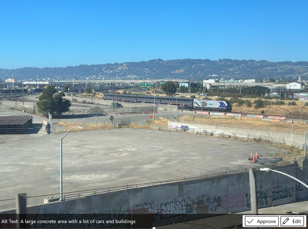 An image of a Capitol Corridor train in Oakland, CA - wrongly labelled by AI as "a lot of cars and buildings"