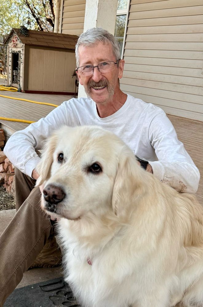 Sampson is sitting with Dad on the stairs outside. Dad is smiling.