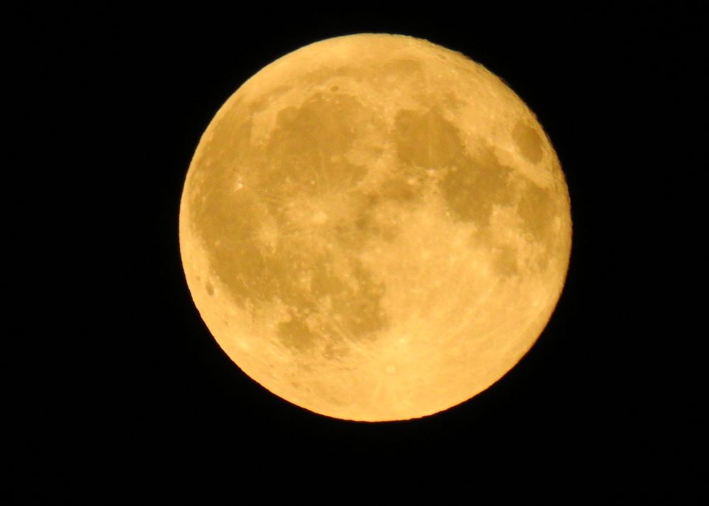 A photo of a full moon in the night sky
