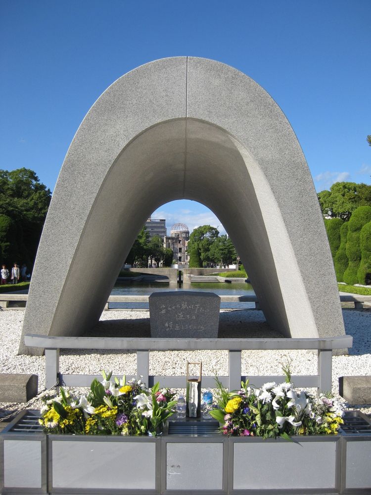 The A-Bomb Dome and Peace Flame seen through the Hiroshima Memorial Cenotaph.