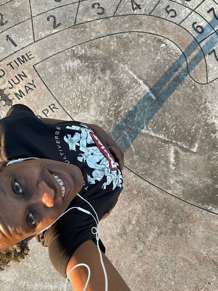 Karama stands on a sundial to determine the time ~7pm