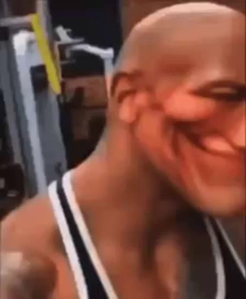 a bald man is smiling in a gym .