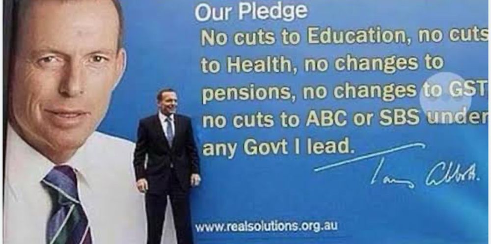 Photo shows Tony Abbott standing in front of a large billboard where he pledges no cuts to health, no changes to pensions, no changes to GST and no cuts to the ABC or SBS under any government he leads. 