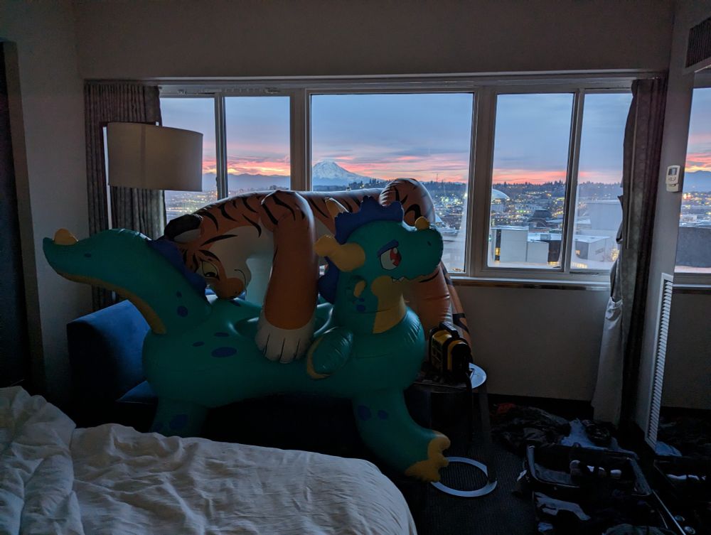 Two pooltoys lounging on the fuck couch in a hotel room overlooking sunrise on Mt. Rainier 