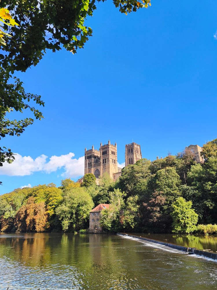 Durham cathedral from across the river, framed against a beautiful blue sky
