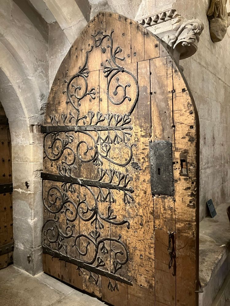 Oak door in Wells Cathedral with decorative iron hinges and scroll work. 