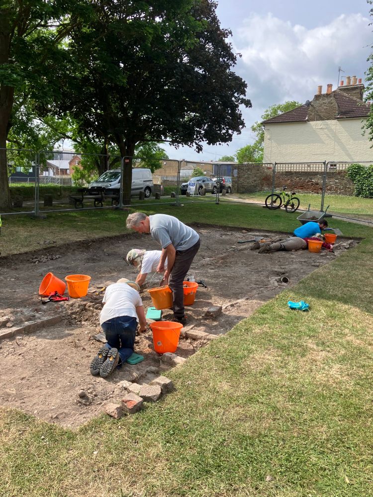 Archaeologists digging the remains of 19th century houses. 