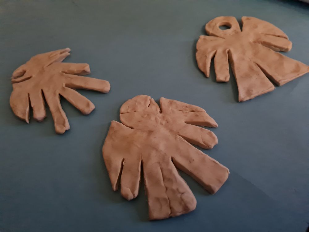 3 characters cut from slabs of dirty white clay, all of slightly varying shapes