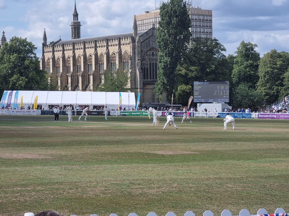 Cricket being played at Cheltenham, chapel in the background