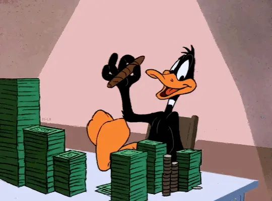 Gif animé.
Daffy Duck devant une table sur laquelle sont placées d’immenses piles de billets.
Le dos complètement calé sur le dossier, les pieds croisés sur la table, il allume un énorme cigare avec un billet.