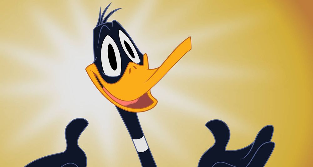 Happy face of Daffy Duck, a bright light behind him.