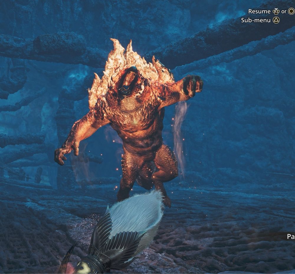 A screenshot from Monster Hunter Wilds. A giant, flaming monkey monster leaps at the camera out of the dark night. Its mouth is open in a roar, and it’s clearly about to ruin the player’s day. At the bottom of the screen is the butt of the player’s glaive weapon, which looks like a cotton bud. 