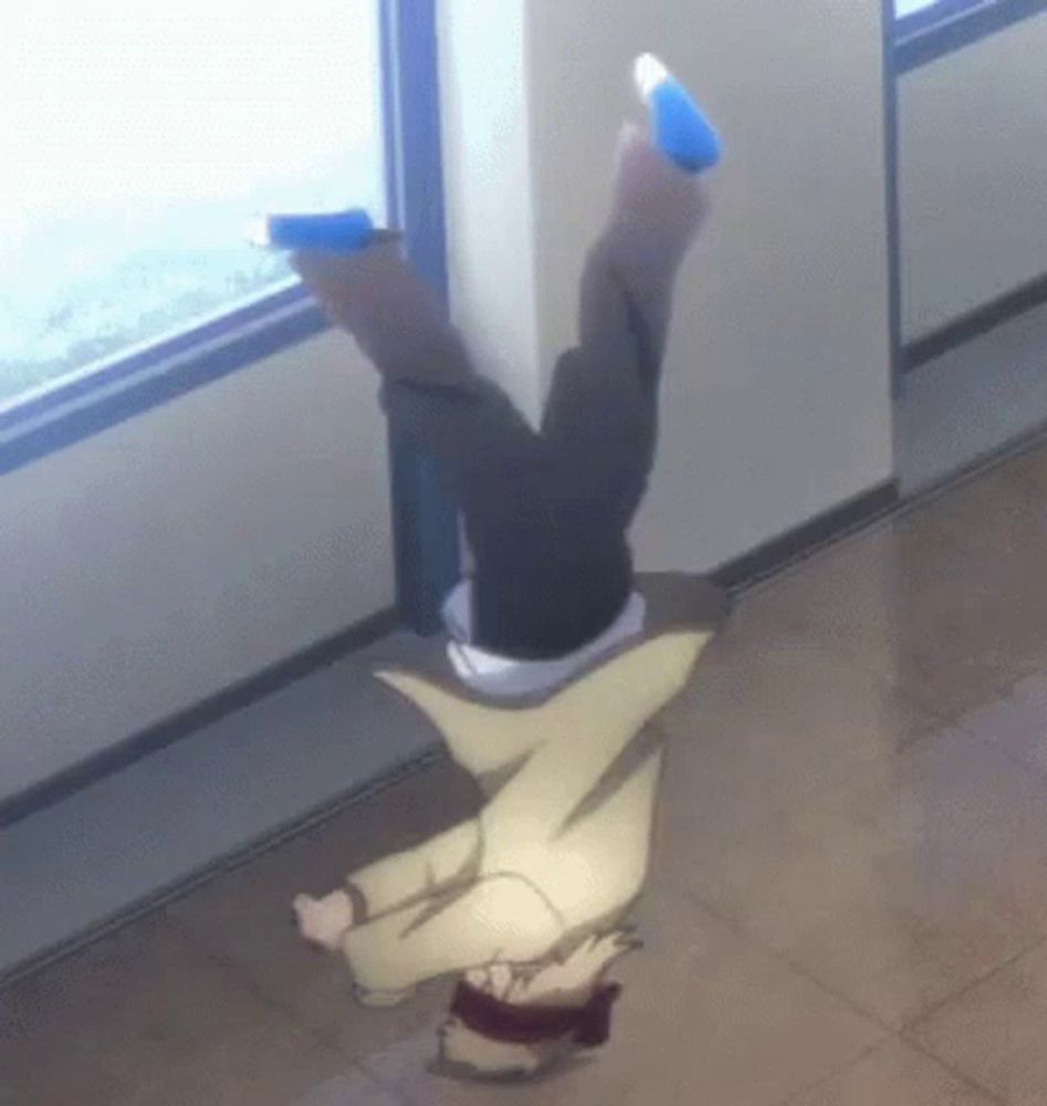 a person is doing a handstand in front of a window in a hallway .