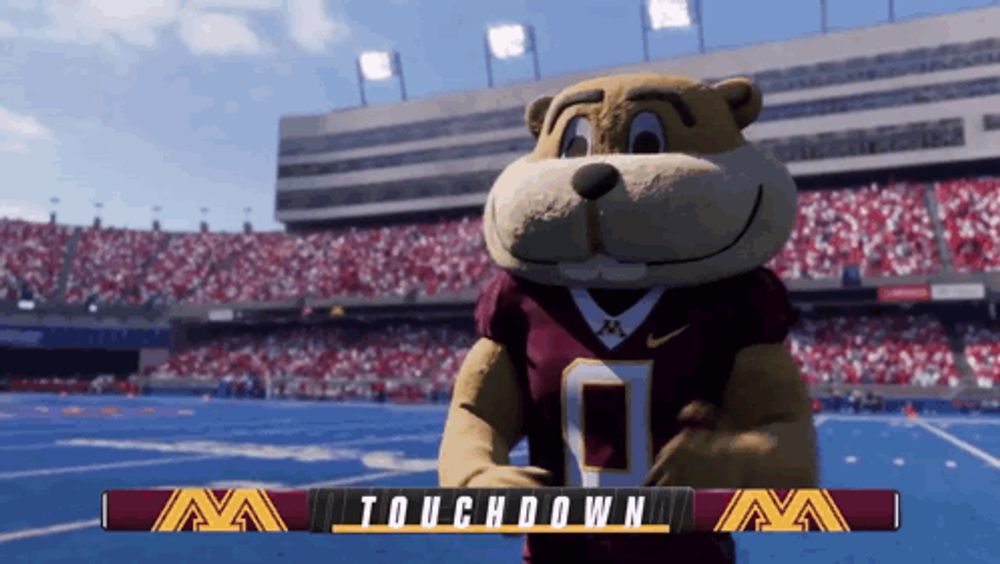 a mascot stands in front of a banner that says touchdown on it