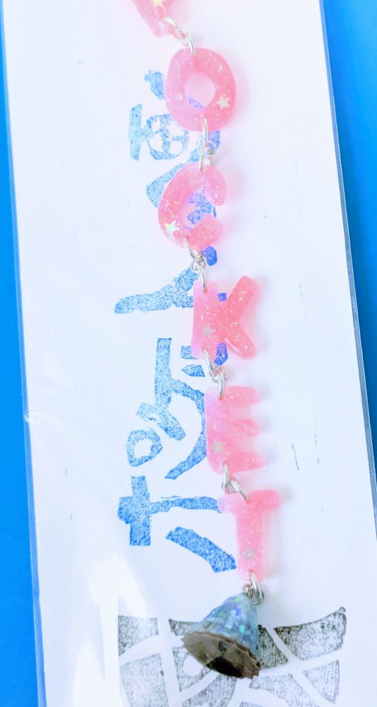 透明なピンク色のアルファベット、P O C K E Tを1文字ずつ繋いだキーホルダー