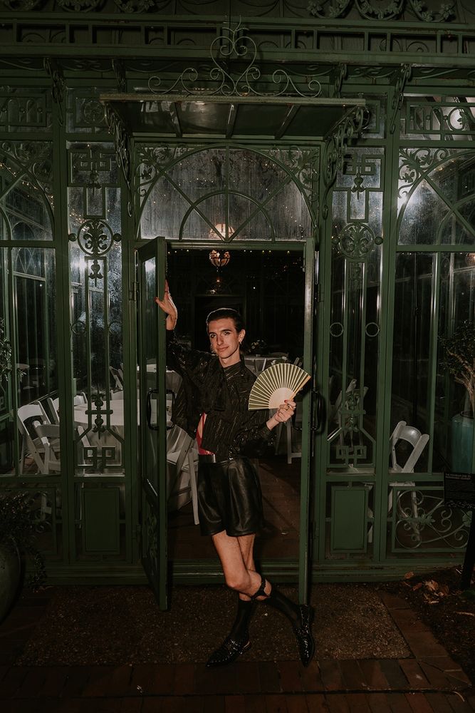 An impromptu shot of me in my wedding attire posing in front of a greenhouse while fanning myself. 