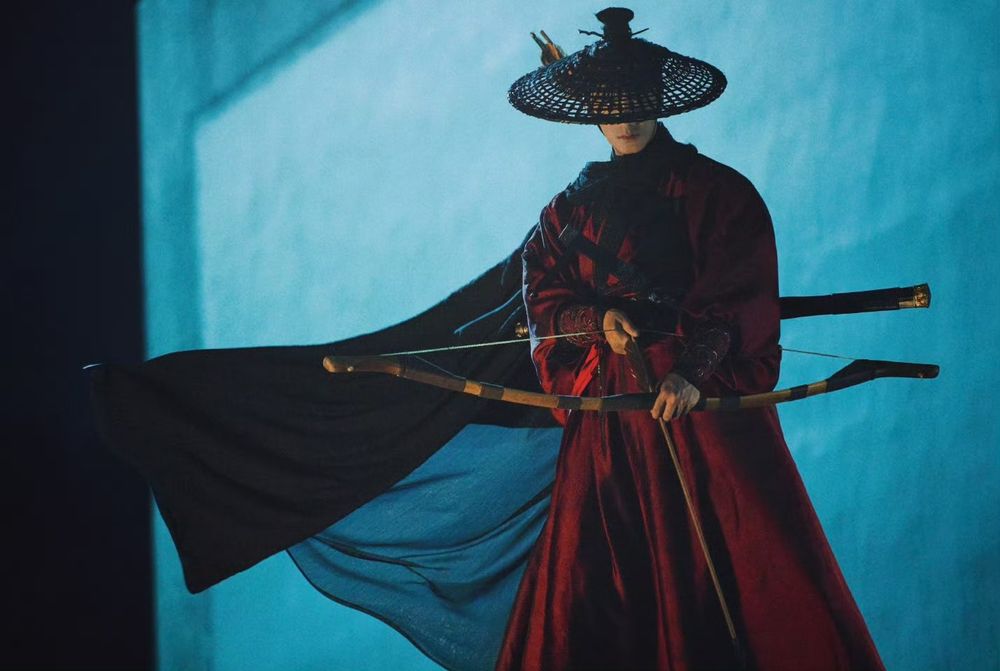 Xiao Shunyao in red costume for SmokePhoenix holding a bow and arrow